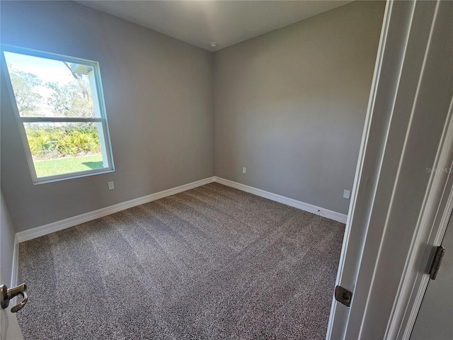 carpeted empty room featuring baseboards