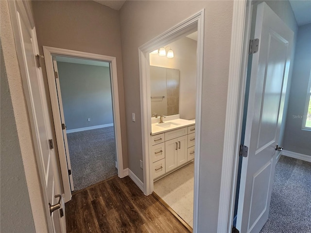 bathroom with vanity, wood finished floors, and baseboards