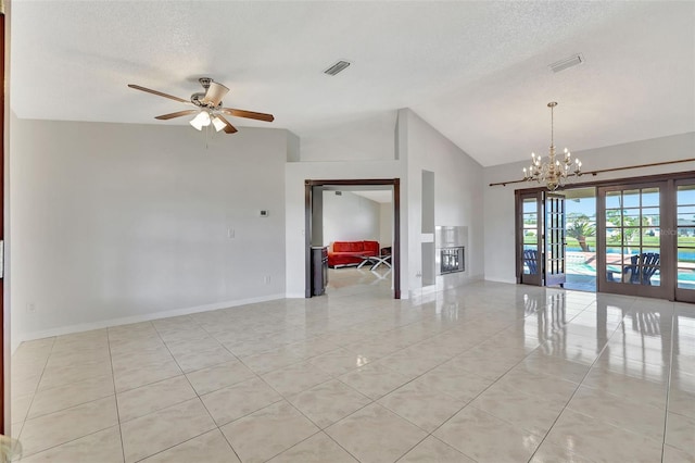 unfurnished room with visible vents, baseboards, vaulted ceiling, ceiling fan with notable chandelier, and a textured ceiling