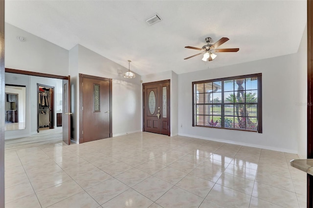 foyer with vaulted ceiling, light tile patterned flooring, ceiling fan with notable chandelier, and visible vents