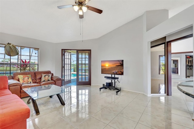 living room featuring light tile patterned floors, baseboards, and ceiling fan