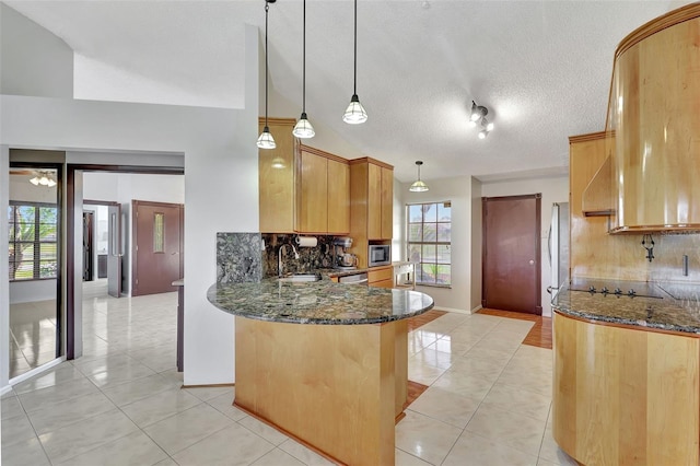 kitchen with light tile patterned floors, a peninsula, dark stone counters, stainless steel appliances, and tasteful backsplash