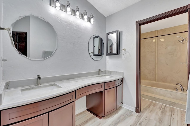 full bathroom with a sink,  shower combination, wood finished floors, and double vanity