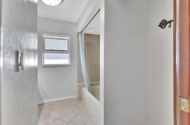 bathroom featuring tile patterned floors, tub / shower combination, and baseboards