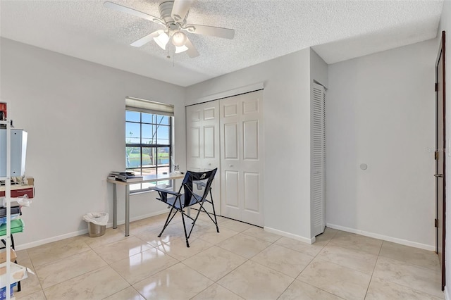 office featuring light tile patterned flooring, a textured ceiling, baseboards, and a ceiling fan