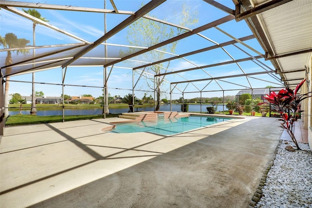 pool featuring glass enclosure, a patio, and a water view