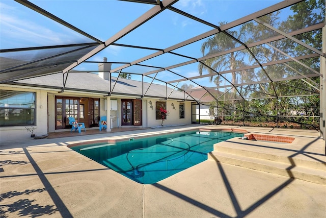 pool with glass enclosure, an in ground hot tub, and a patio area