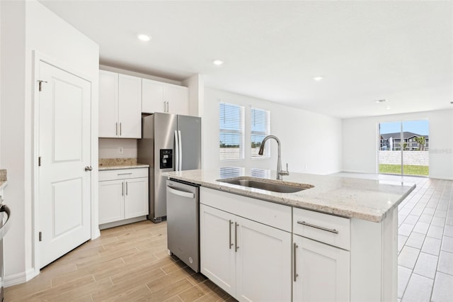 kitchen featuring white cabinets, a healthy amount of sunlight, stainless steel appliances, and a sink