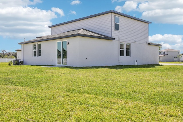 back of house featuring a lawn and stucco siding