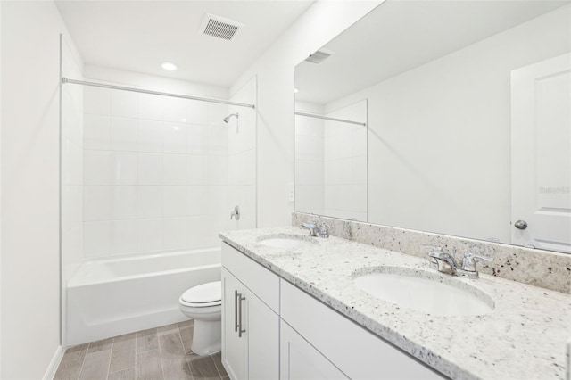 bathroom featuring visible vents, a sink, double vanity, and toilet