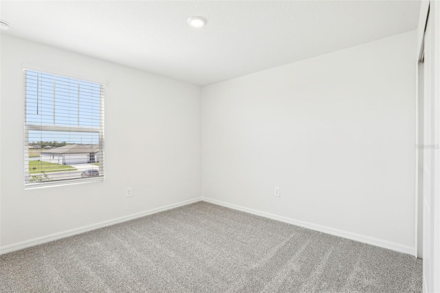 carpeted empty room with baseboards
