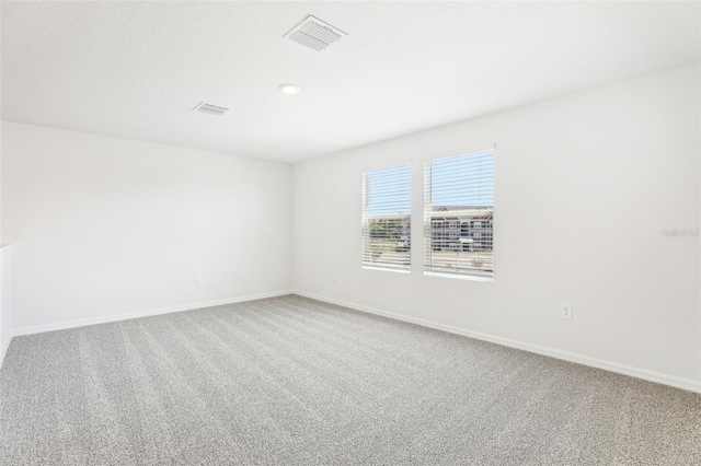 unfurnished room with visible vents, carpet flooring, and baseboards