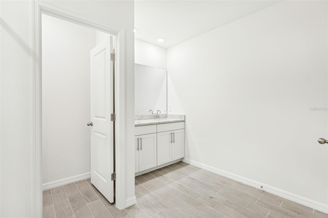 bathroom featuring baseboards, vanity, and wood tiled floor
