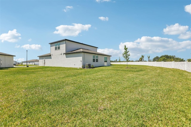 view of yard featuring central AC unit and fence