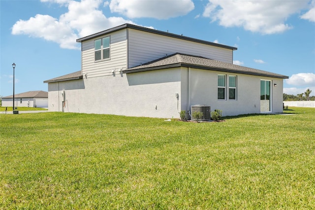 view of property exterior featuring a lawn, cooling unit, a shingled roof, and stucco siding