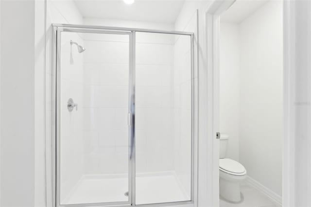 bathroom featuring a shower stall and toilet