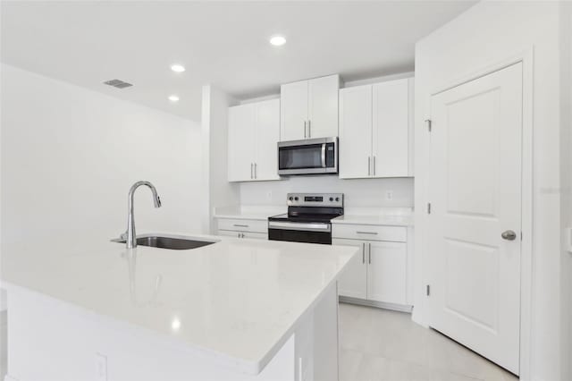kitchen featuring visible vents, white cabinetry, stainless steel appliances, and a sink