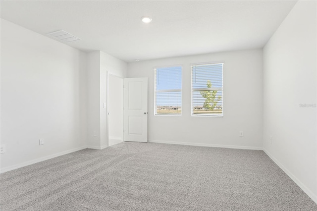 carpeted empty room featuring recessed lighting, visible vents, and baseboards