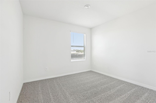 spare room with baseboards and carpet