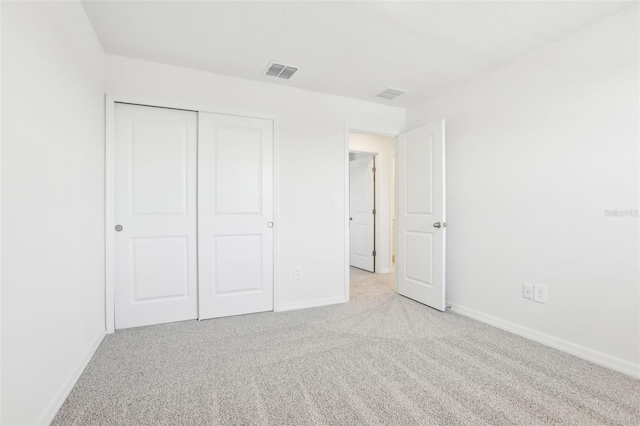 unfurnished bedroom with a closet, visible vents, carpet flooring, and baseboards