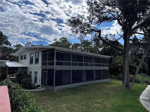 back of property with a lawn and a sunroom