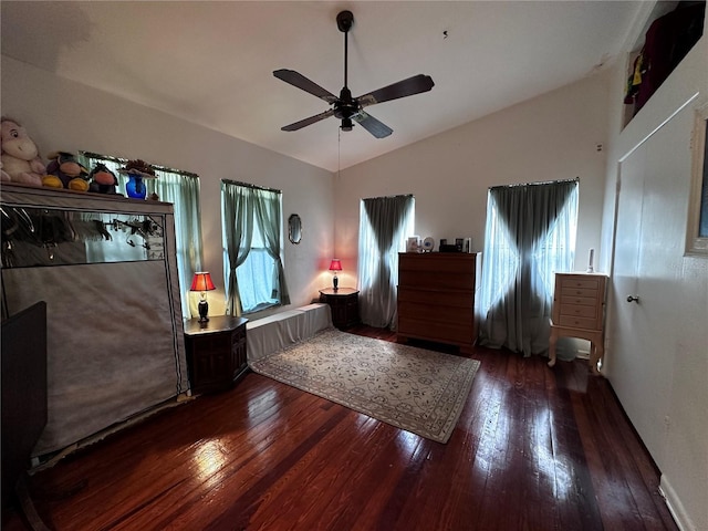 bedroom featuring ceiling fan, hardwood / wood-style flooring, multiple windows, and vaulted ceiling