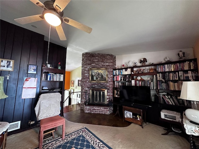 sitting room featuring visible vents, a brick fireplace, a ceiling fan, and vaulted ceiling