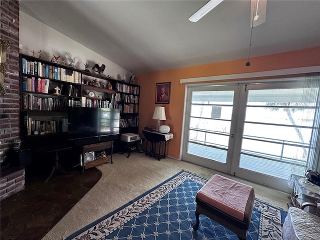 carpeted office space featuring vaulted ceiling and a ceiling fan