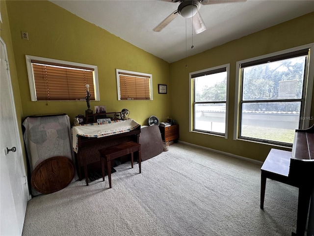 carpeted home office with baseboards, ceiling fan, and vaulted ceiling