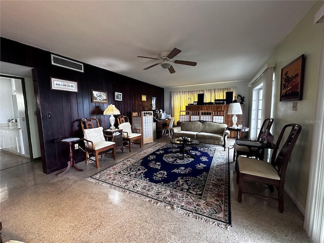 living room with visible vents, baseboards, ceiling fan, and speckled floor