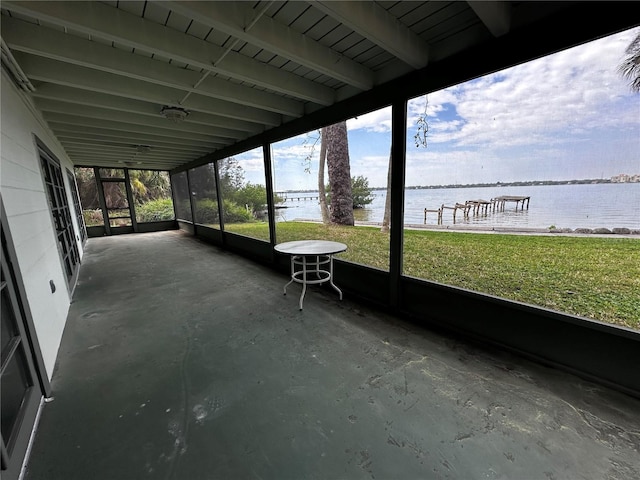 unfurnished sunroom featuring a water view