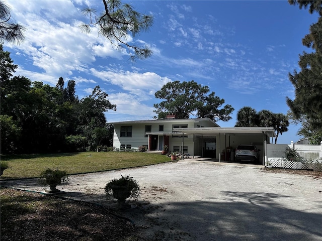 view of front facade featuring a front lawn, a carport, fence, and driveway