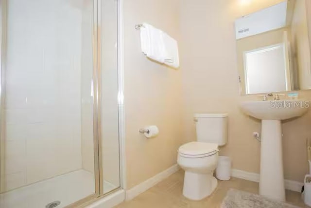 full bath featuring a shower stall, toilet, and baseboards