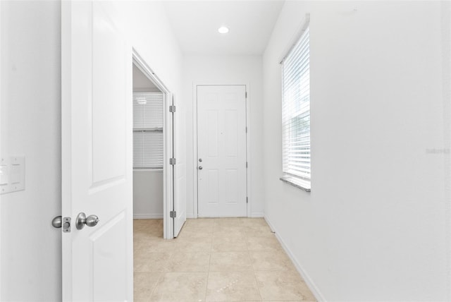 hall featuring light tile patterned flooring, recessed lighting, and baseboards