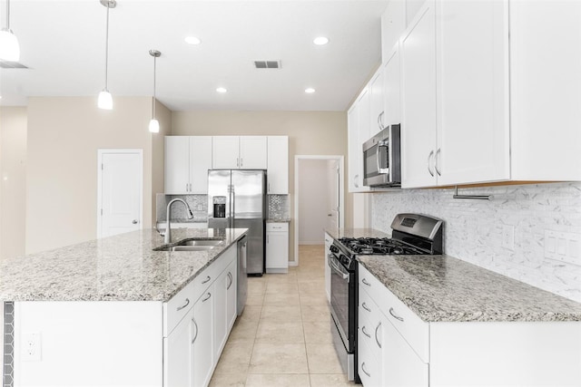 kitchen with visible vents, light stone countertops, appliances with stainless steel finishes, white cabinetry, and a sink