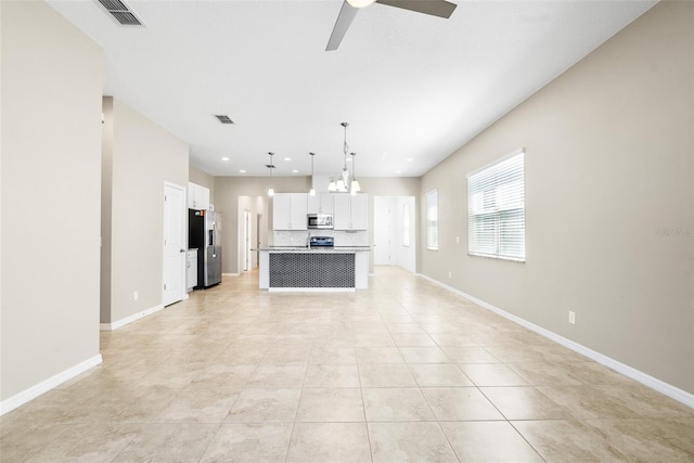 interior space featuring baseboards, visible vents, and ceiling fan