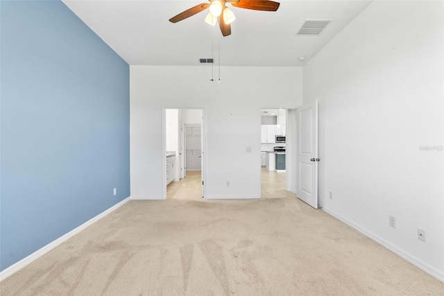 unfurnished bedroom featuring visible vents, baseboards, light colored carpet, and a walk in closet