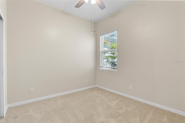 spare room featuring light carpet, baseboards, and a ceiling fan