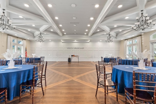 dining area featuring beam ceiling, wood finished floors, coffered ceiling, and a chandelier