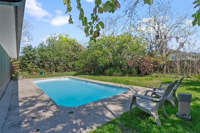 pool with a patio area, a yard, and fence