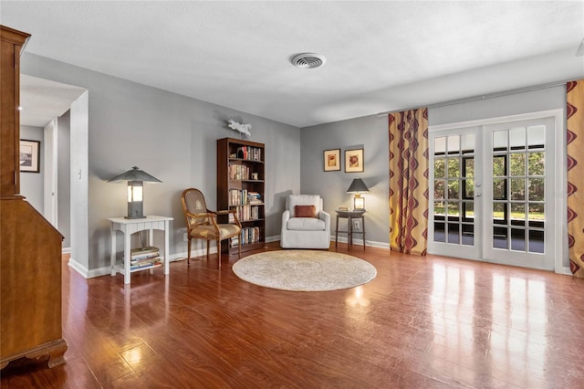 sitting room featuring visible vents, baseboards, and wood finished floors