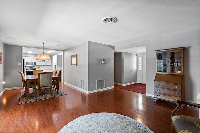 dining area with visible vents and wood finished floors