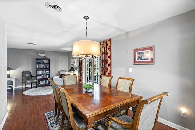 dining room featuring dark wood finished floors, visible vents, and baseboards