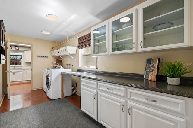 laundry room with cabinet space, dark wood-style flooring, and washer and clothes dryer