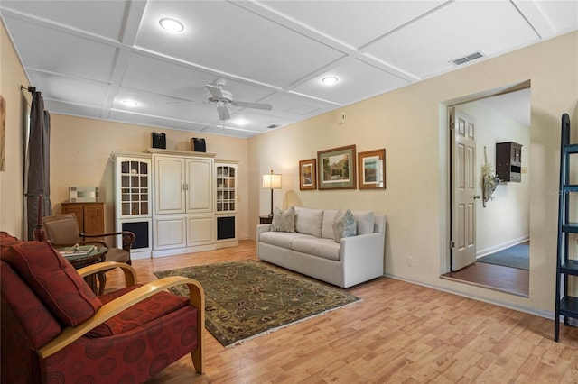 living room with visible vents, coffered ceiling, ceiling fan, and light wood-style flooring