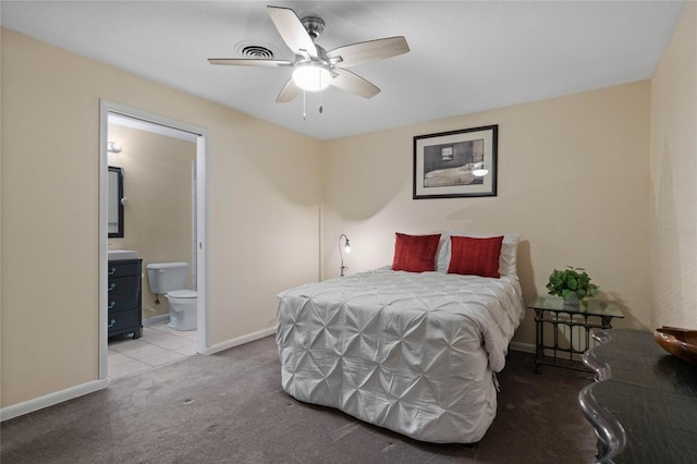 carpeted bedroom featuring a ceiling fan, ensuite bathroom, and baseboards