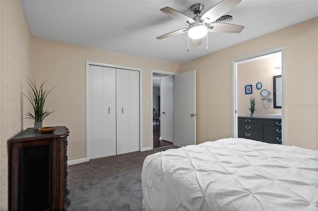 bedroom with visible vents, a ceiling fan, ensuite bath, a closet, and dark colored carpet