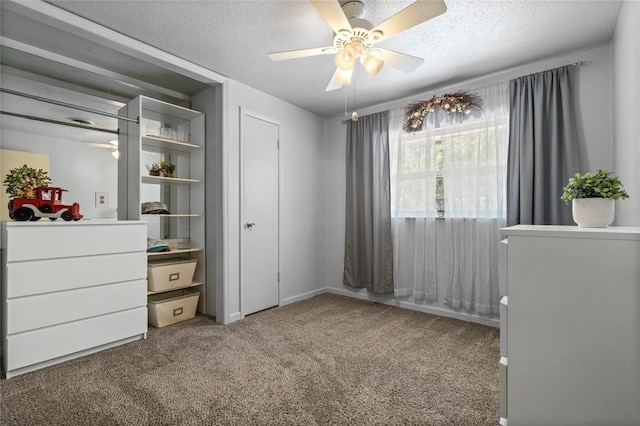 unfurnished bedroom with ceiling fan, a textured ceiling, and carpet