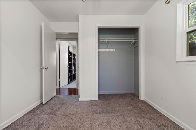 unfurnished bedroom with baseboards, a closet, and carpet floors