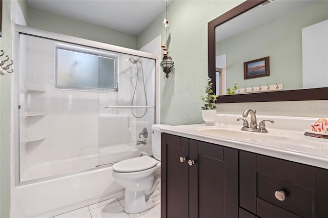 full bath featuring tile patterned flooring, toilet, a textured wall, combined bath / shower with glass door, and vanity